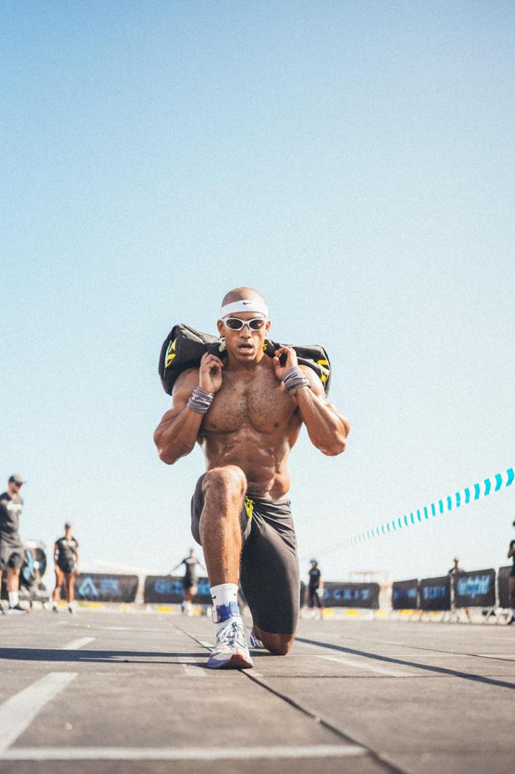 Atleta haciendo zancadas con un saco a la espalda